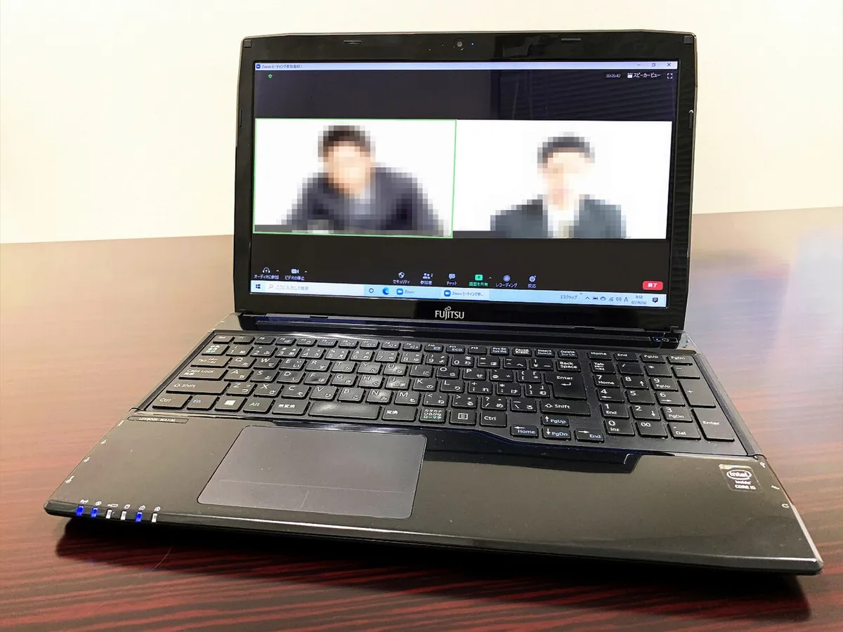 Laptop showing a video call with two participants